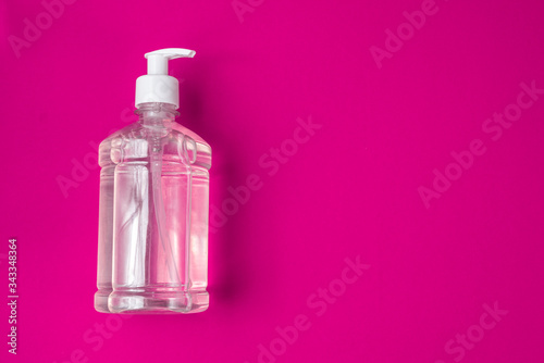 Container with alcohol gel on the red background © Mateus