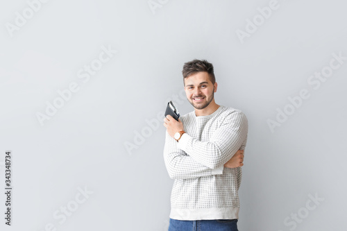 Man with purse on light bac...