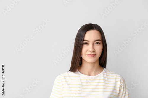 Portrait of beautiful young woman on grey background © Pixel-Shot