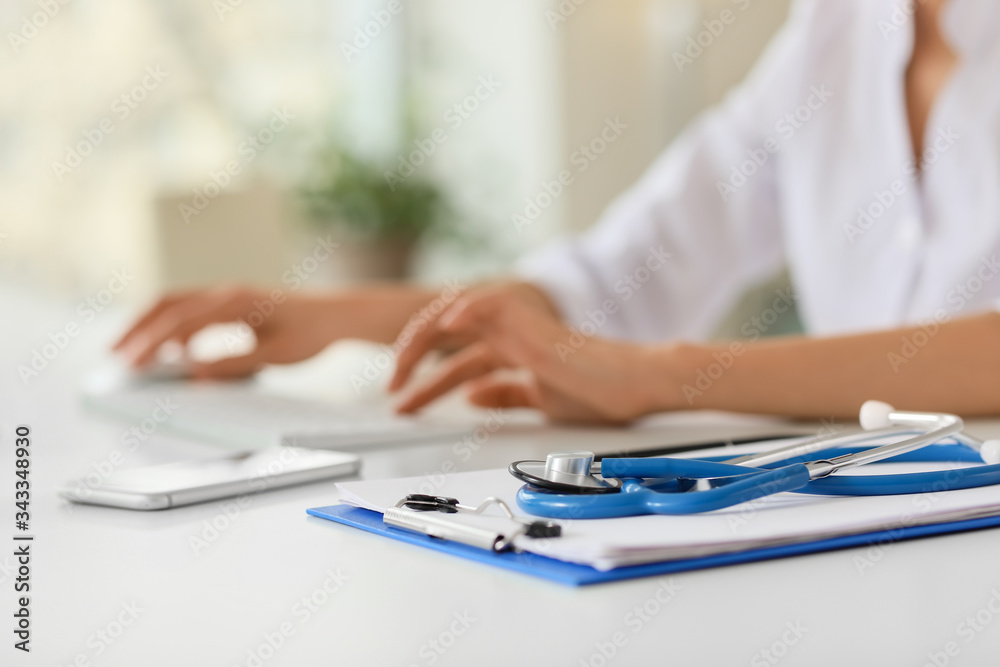Clipboard and stethoscope on table in clinic Clipboard and stethoscope on table in clinic