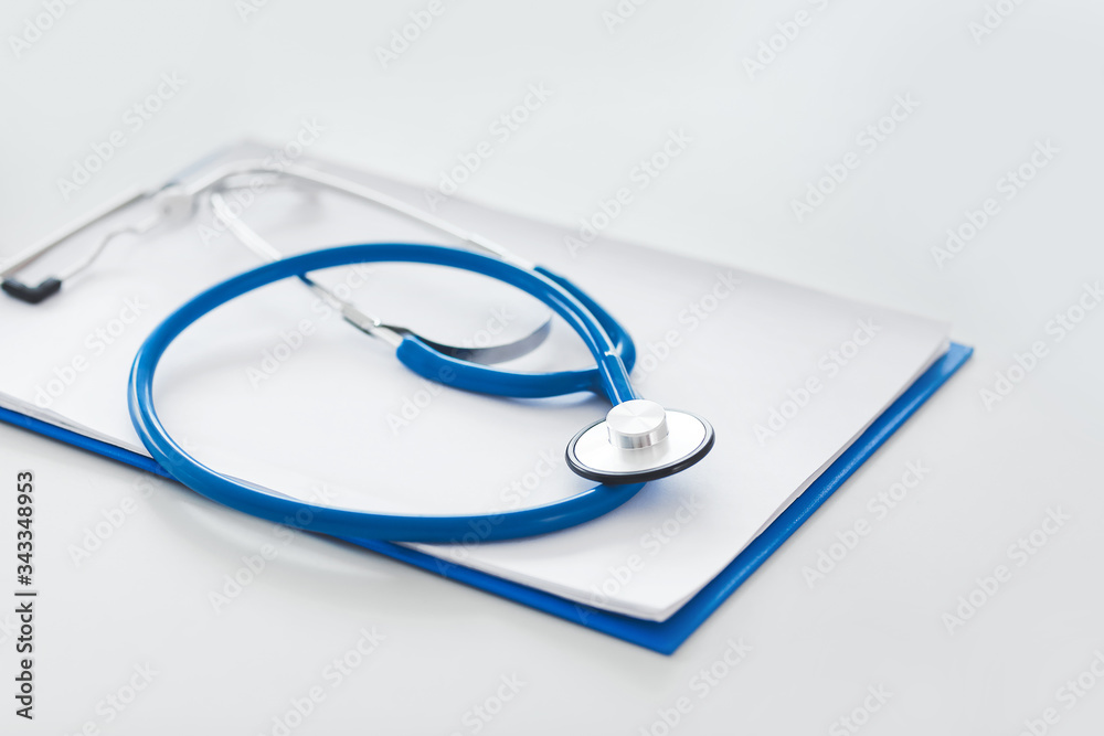 Clipboard and stethoscope on table in clinic Clipboard and stethoscope on table in clinic