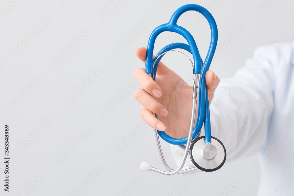 Female doctor with stethoscope on light background Female doctor with stethoscope on light background