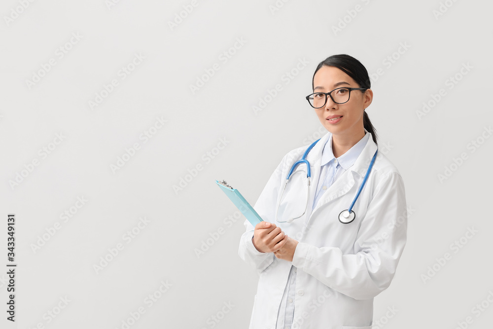 Female Asian doctor on light background Female Asian doctor on light background