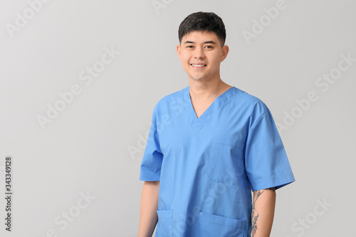 Male Asian doctor on light ...
