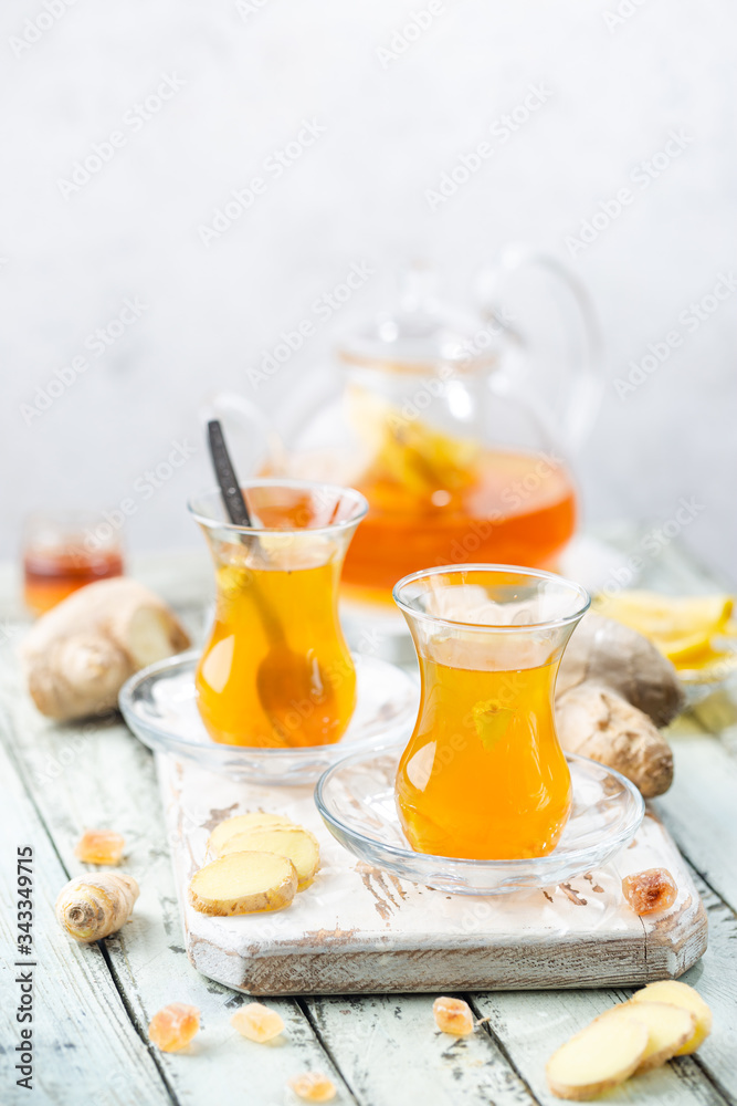 Ginger tea in a glass cup with lemon and mint on light background Ginger tea in a glass cup with lemon and mint on light background
