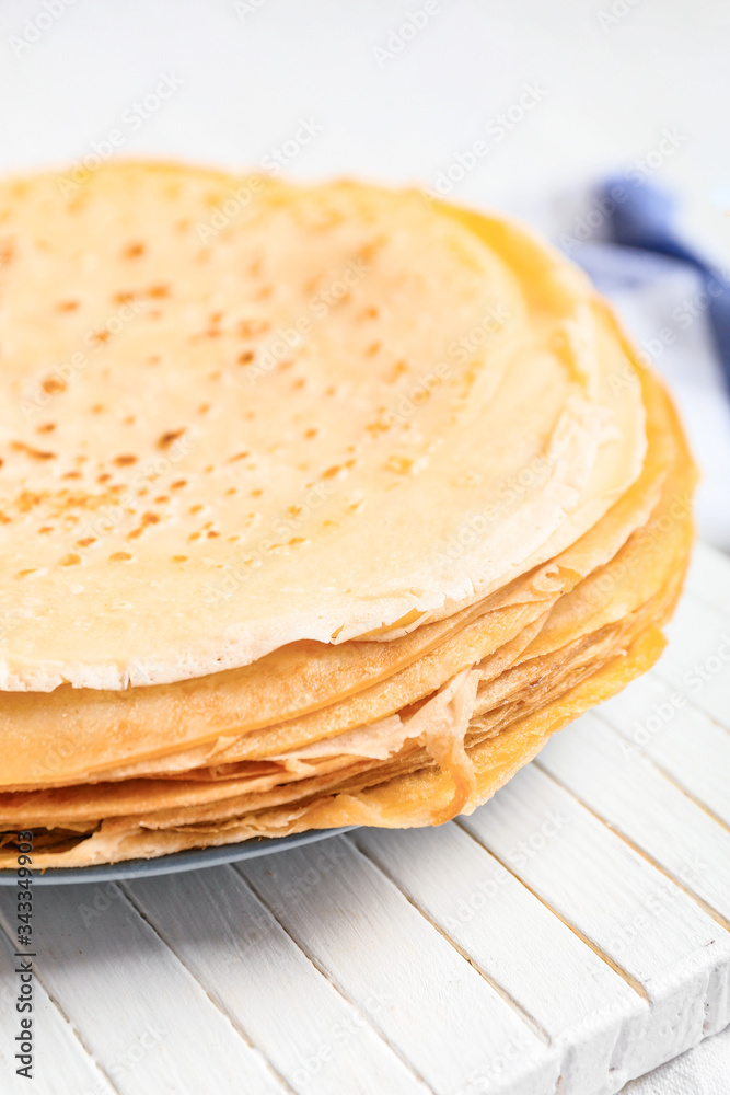 Board with tasty blini on table, closeup Board with tasty blini on table, closeup
