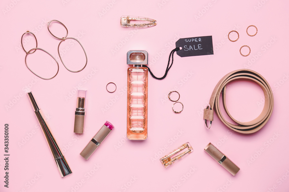 Bottle of perfume for sale with makeup cosmetics and accessories on color background Bottle of perfume for sale with makeup cosmetics and accessories on color background