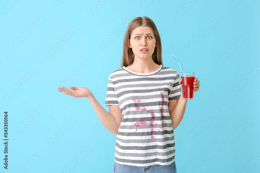 Troubled woman in dirty clothes drinking juice on color background Troubled woman in dirty clothes drinking juice on color background