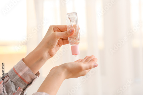 Woman using sanitizer at home