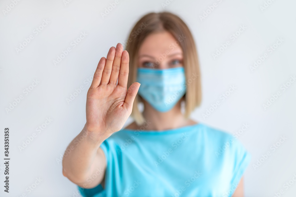Attractive female nurse showing stop sign with his hand gesture isolated on white background Attractive female nurse showing stop sign with his hand gesture isolated on white background