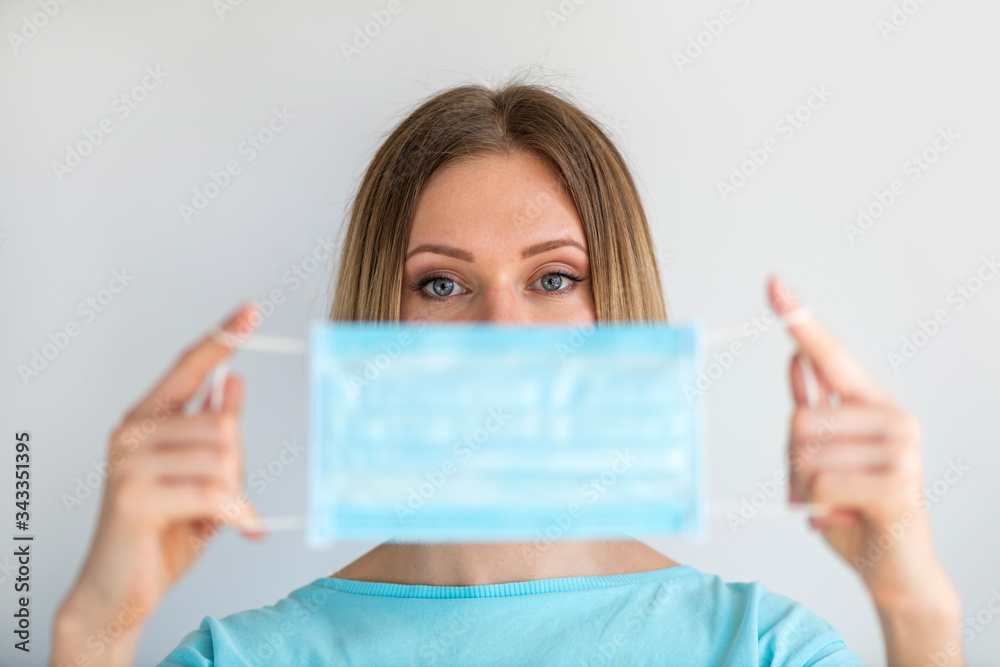 Doctor or nurse holding in hand closeup face mask on white background. Focus on woman. Medical concept to prevent the spread of the virus Doctor or nurse holding in hand closeup face mask on white background. Focus on woman. Medical concept to prevent the spread of the virus
