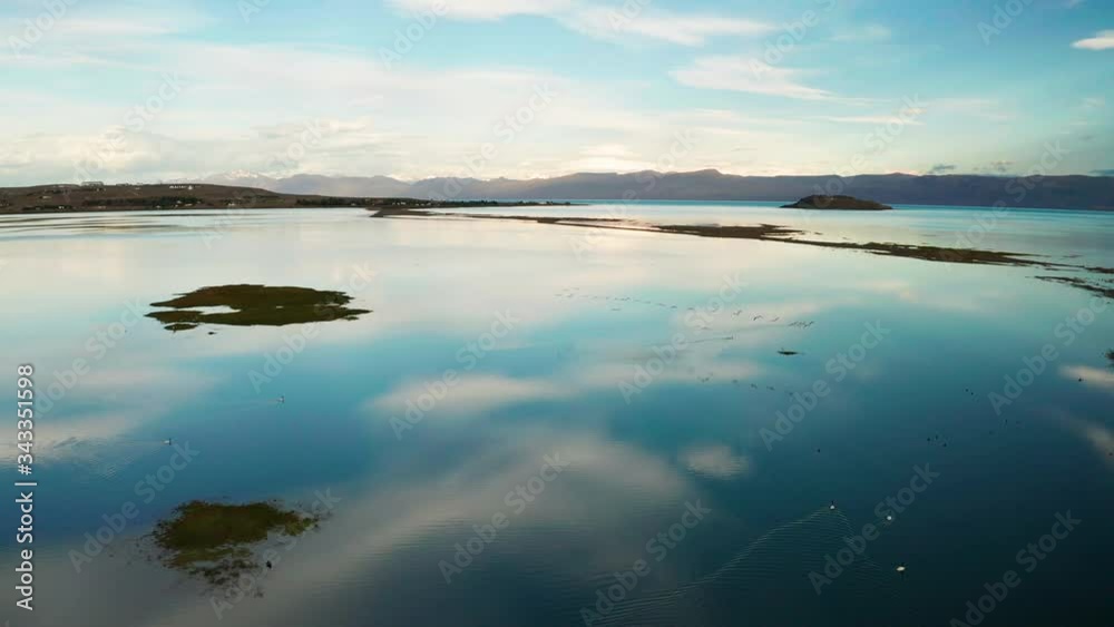 Aerial view of flamingos flying over the lake at dawn. Patagonia, Argentina, Lago Argentino Aerial view of flamingos flying over the lake at dawn. Patagonia, Argentina, Lago Argentino