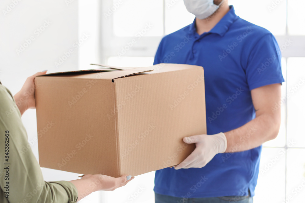 Woman receiving parcel from courier at home