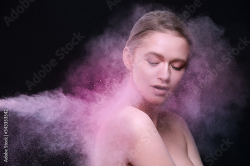 Beauty Products And Makeup Cosmetics. Beautiful Female Model Posing With Flying Pink Blush Powder On Face And Body. Fashionable Sexy Young Woman In Colored Cloud Of Cosmetic Powder. High Resolution