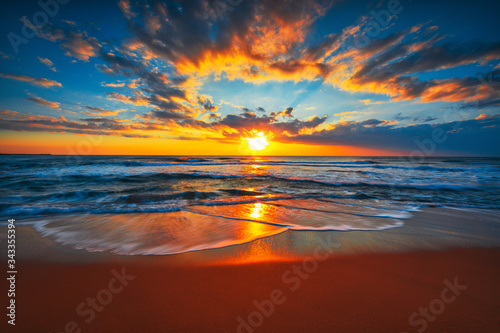 Fototapeta Naklejka Na Ścianę i Meble -  Sunrise on the beach and ocean waves on a tropical sea