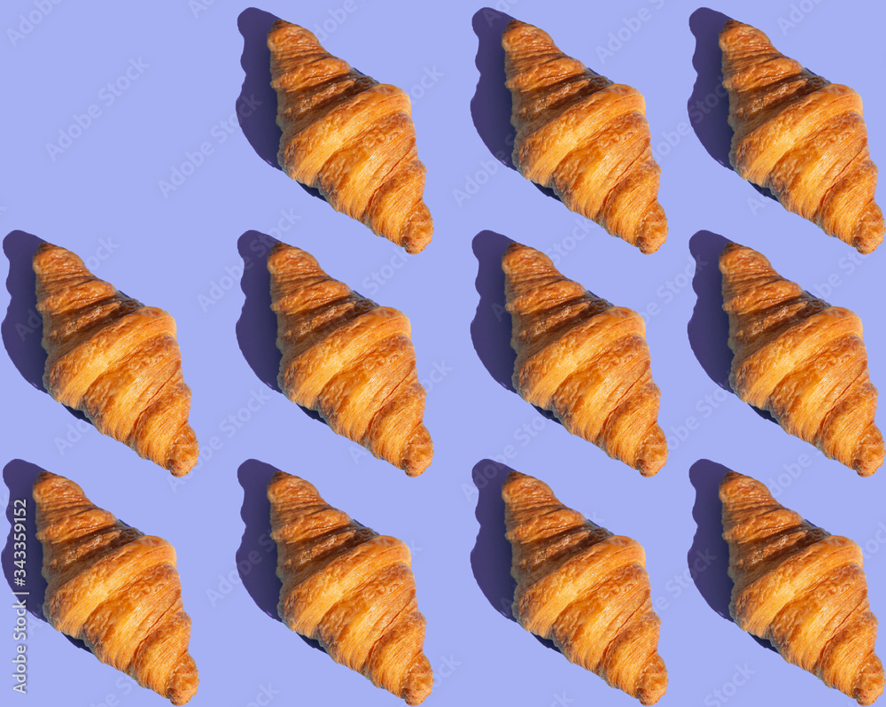 Bakery products pattern with baked croissant. Purple background, top view. Pop art style. Delicious and food concept.