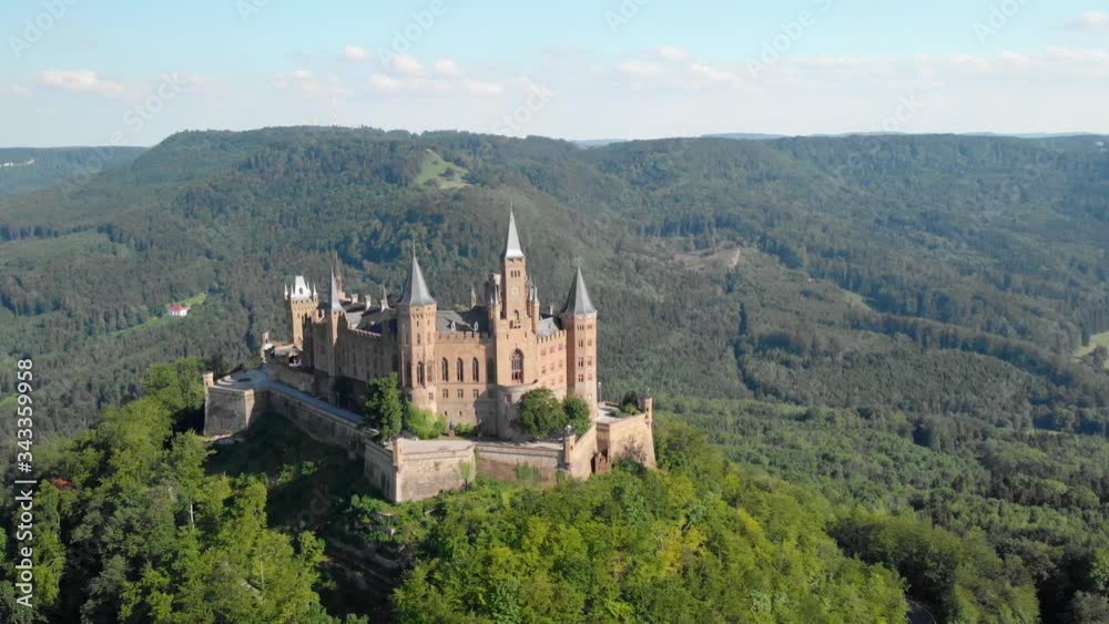 Burg Hohenzollern castle, Aerial, drone shot towards a old hilltop fortress, surrounded by green forest, summer day, in Baden-Wurttemberg, Swabia, Germany - HD crop Burg Hohenzollern castle, Aerial, drone shot towards a old hilltop fortress, surrounded by green forest, summer day, in Baden-Wurttemberg, Swabia, Germany - HD crop
