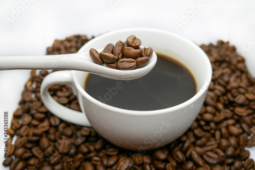 white coffee cup, spoon and roasted coffee beans that isolated on white background. top view.
