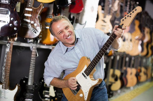 Happy man is playing on new electric guitar