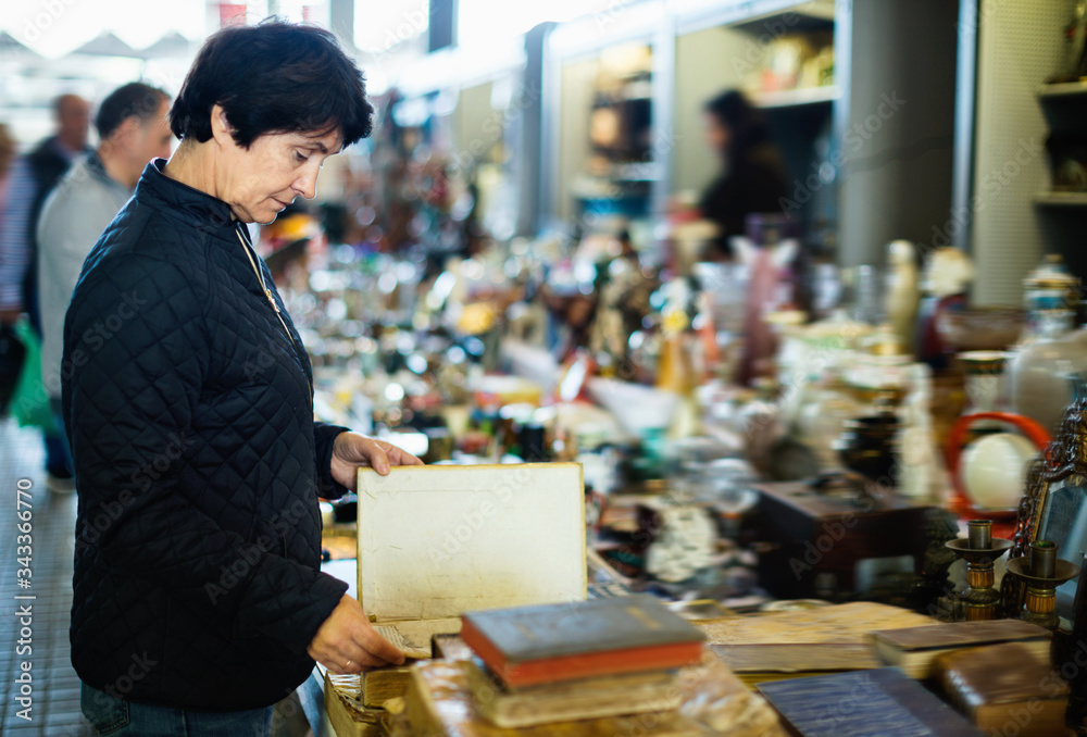 Portrait of senior woman choosing vintage goods at flea market