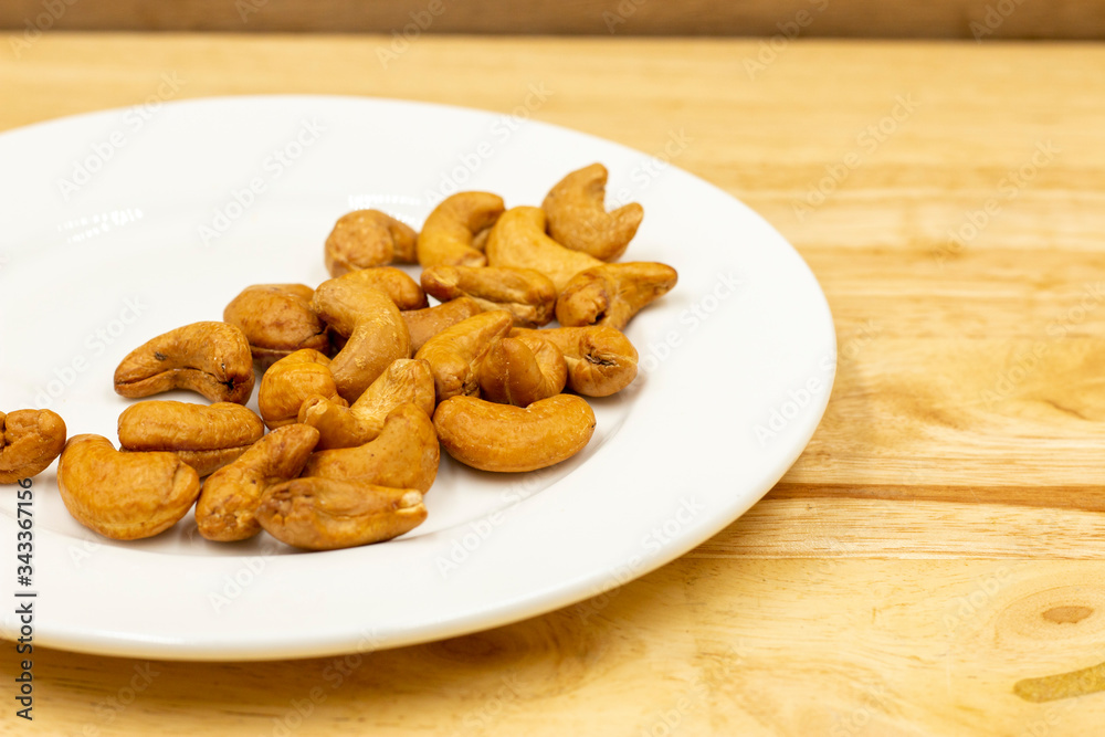 The cashew tree is a tropical evergreen tree that produces the cashew seed and the cashew apple. The tree can grow as high as 14 m, but the dwarf cashew, growing up to 6 m, has proved more profitable,