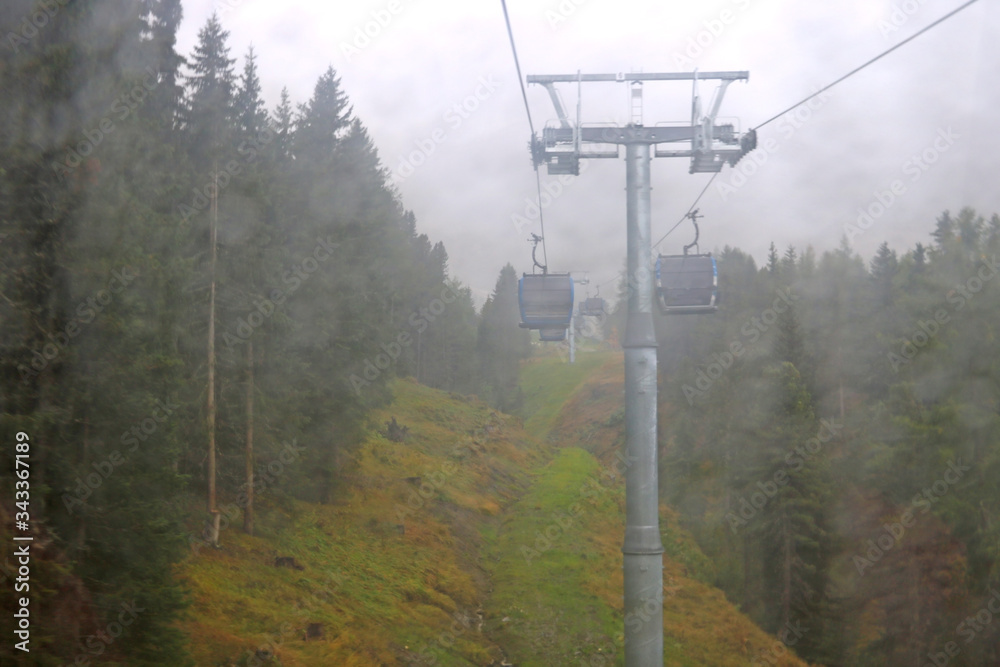 Cabin of Cable car lift arrive to top of the mountain with place of rest, restaurant and hotel in foggy day. Dolomites, Italy.