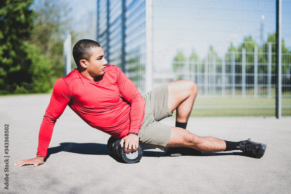 Fototapeta premium Junger muskulöser Mann beim Sport im Freien 