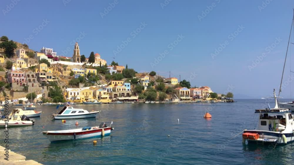 Symi Town harbour and church on hill tilt, Summer, daytime, Symi, Greece Symi Town harbour and church on hill tilt, Summer, daytime, Symi, Greece