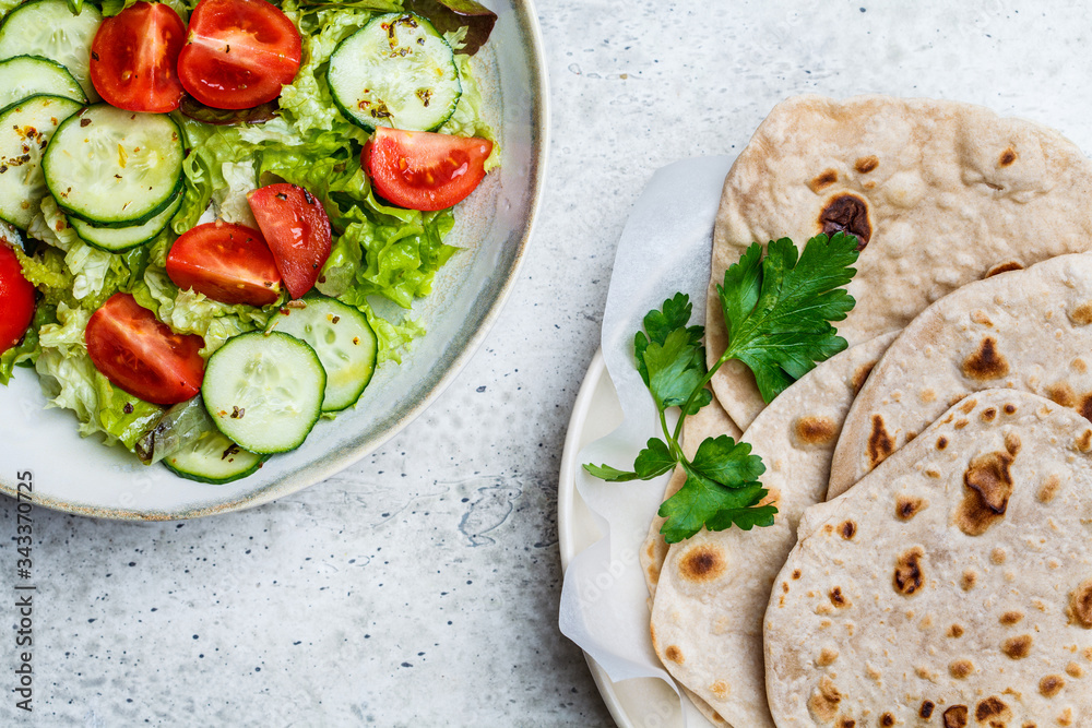 Homemade indian flatbread chapati on a gray background. Vegetarian cuisine concept. Homemade indian flatbread chapati on a gray background. Vegetarian cuisine concept.