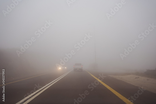 Obraz na płótnie Car and truck driving in dense fog in the mountains near Abha w salonie