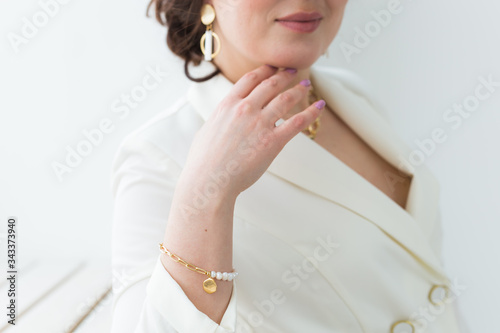 Girl in white suit with make-up posing on a white room. Fashion style body length studio portrait. Elegant fashionable woman.
