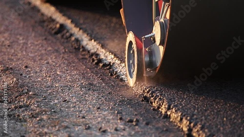 The paver mover on a flat newly made road, ramming and leveling. Asphalt paver applying asphalt on the repaired city road