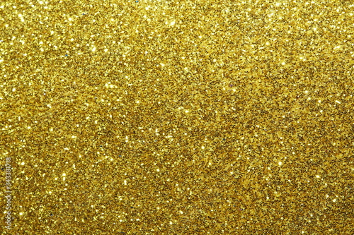 gold Sparkling Lights Festive background with texture. Abstract Christmas twinkled bright bokeh defocused and Falling stars. Winter Card or invitation	