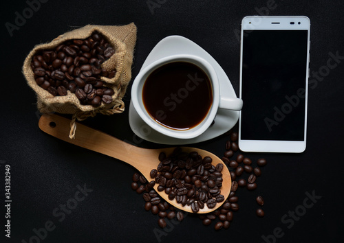 The big wood spoon  glass of coffe and coffee beans with black background