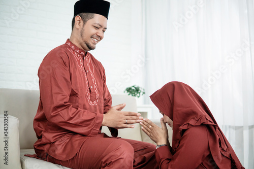 Slika na platnu a wife kneel bow to his husband for apologize and say happy Eid day