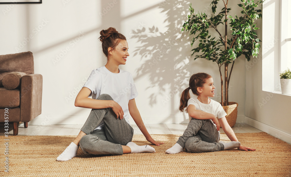 Cheerful mother with girl doing yoga together