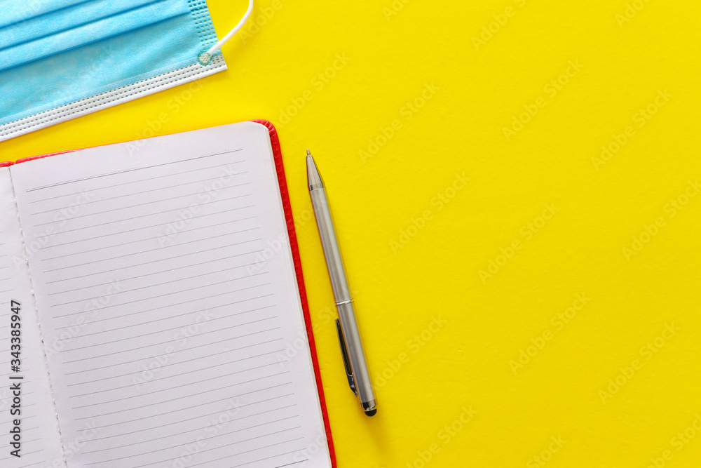 concept image of home office. Covid-19 Coronavirus quarantine with empty notebook over yellow background concept image of home office. Covid-19 Coronavirus quarantine with empty notebook over yellow background