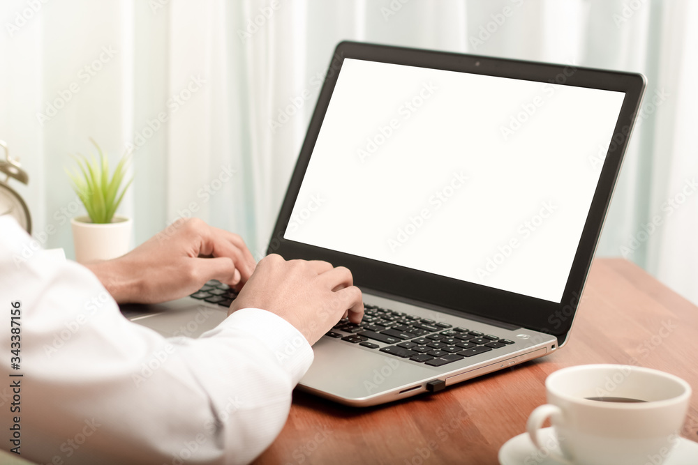 Business man working on laptop computer at home while sitting the wooden table.Male hands typing on the notebook keyboard.Online shopping,Working from home,Coronavirus,Internet usage Business man working on laptop computer at home while sitting the wooden table.Male hands typing on the notebook keyboard.Online shopping,Working from home,Coronavirus,Internet usage