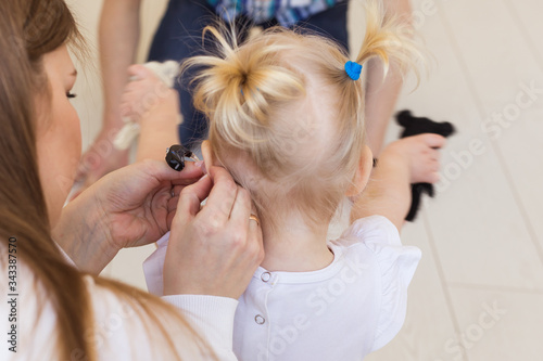 Baby girl wearing a hearing aid. Disabled child, disability and deafness concept.