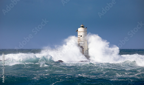 The lighthouse of the boat-eater shrouded by the waves of a mistral wind storm photo