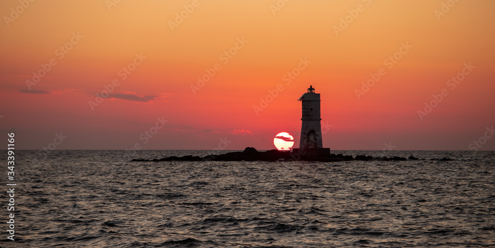  The Mangiabarche lighthouse wrapped in the waves of a mistral wind storm in a beautiful sunset