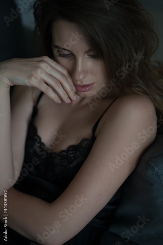 Beautiful young sexy woman with puffy lips in black lace nightie pajamas. Soft selective focus.