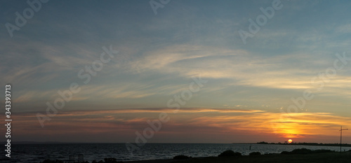 Panorama of the sun setting over a beach coastal scene along the bay near Melbourne, Victoria, Australia