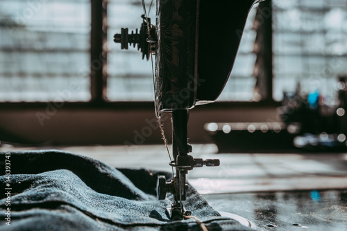 Closeup the sewing machine and item on denim jeans, old sewing machine.