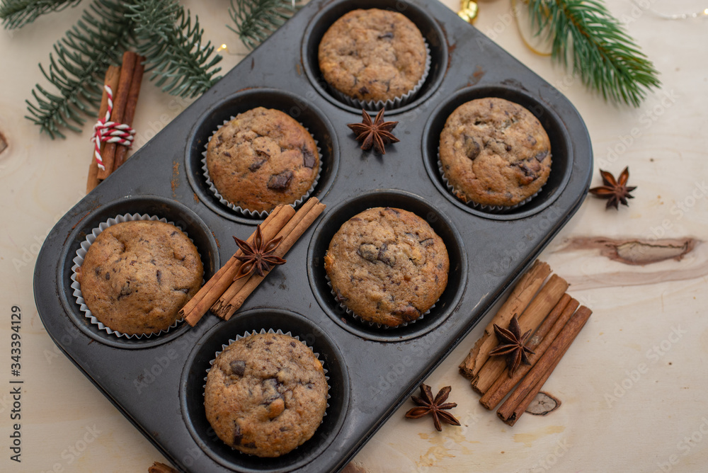 fresh chocolate muffins in muffin tin on wooden surface