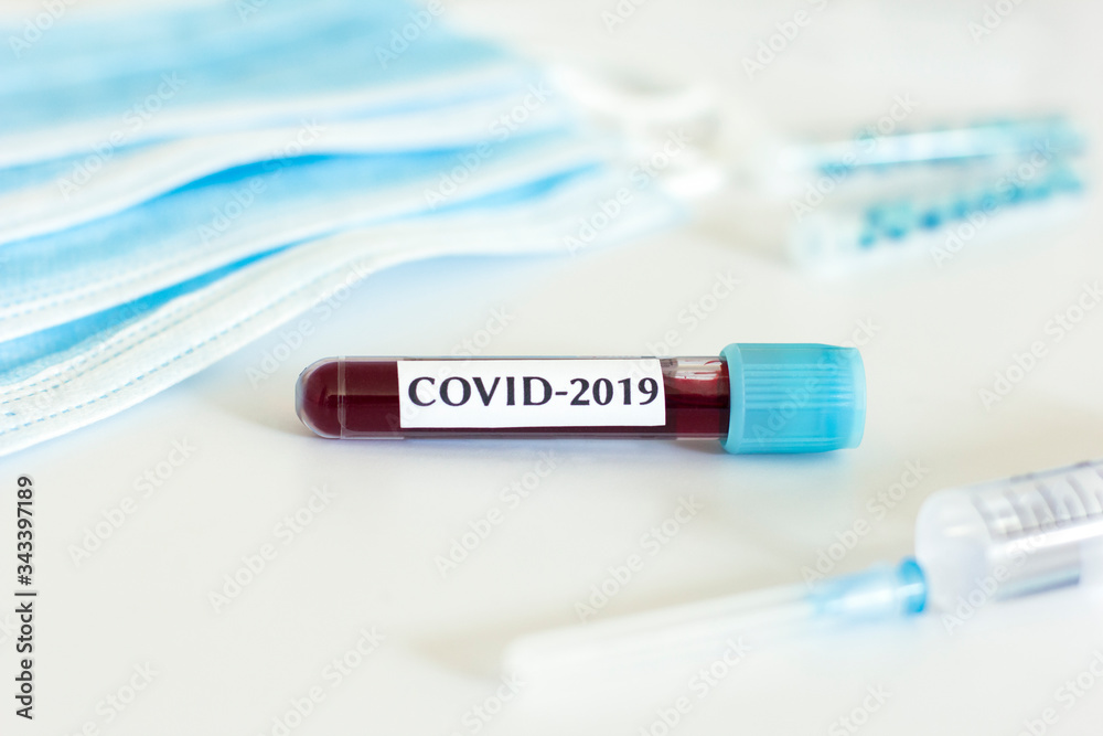 Obraz premium Coronavirus blood test, syringe and protective masks on white background. 2019-nCov epidemic virus concept.