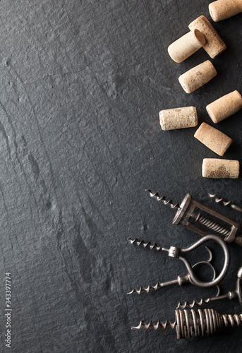 Corkscrews and corks on a dark background.