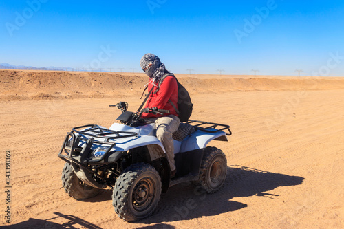 Young man in safari trip through egyptian desert driving ATV. Quad bikes safari in the desert near Hurghada, Egypt