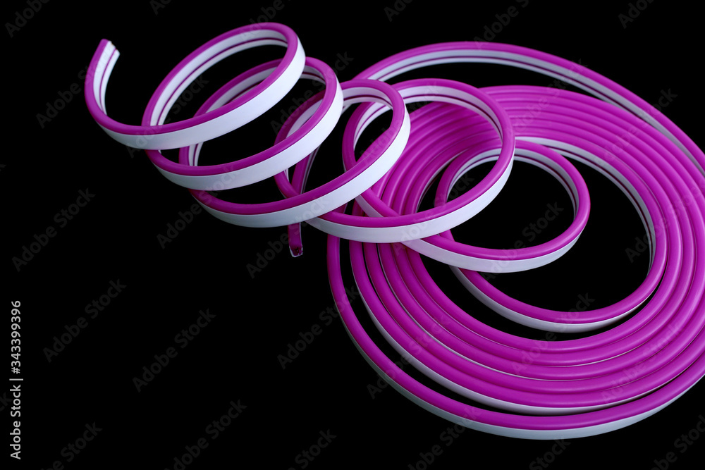 Violet flexible LED neon on black isolated background. Flat lay, copy space, top view. Trendy neon colors background. Violet flexible LED neon on black isolated background. Flat lay, copy space, top view. Trendy neon colors background.