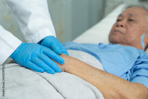 Doctor holding touching hands Asian senior or elderly old lady woman patient with love, care, helping, encourage and empathy at nursing hospital ward : healthy strong medical concept